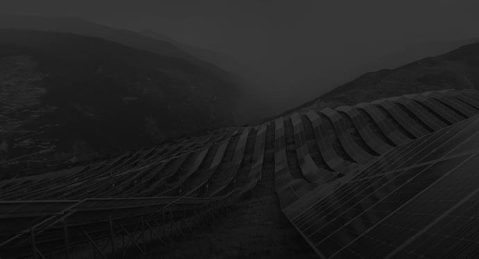 Explore Innovations First-Hand Large solar panel farm installed on hilly terrain.